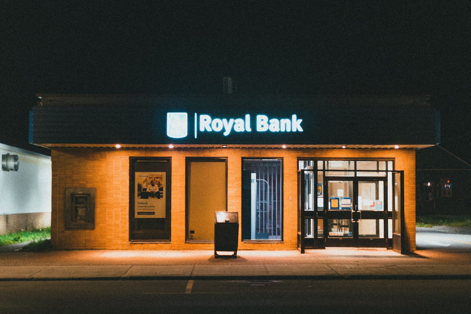 Exterior view of a Royal Bank building at night with glowing facade lights.